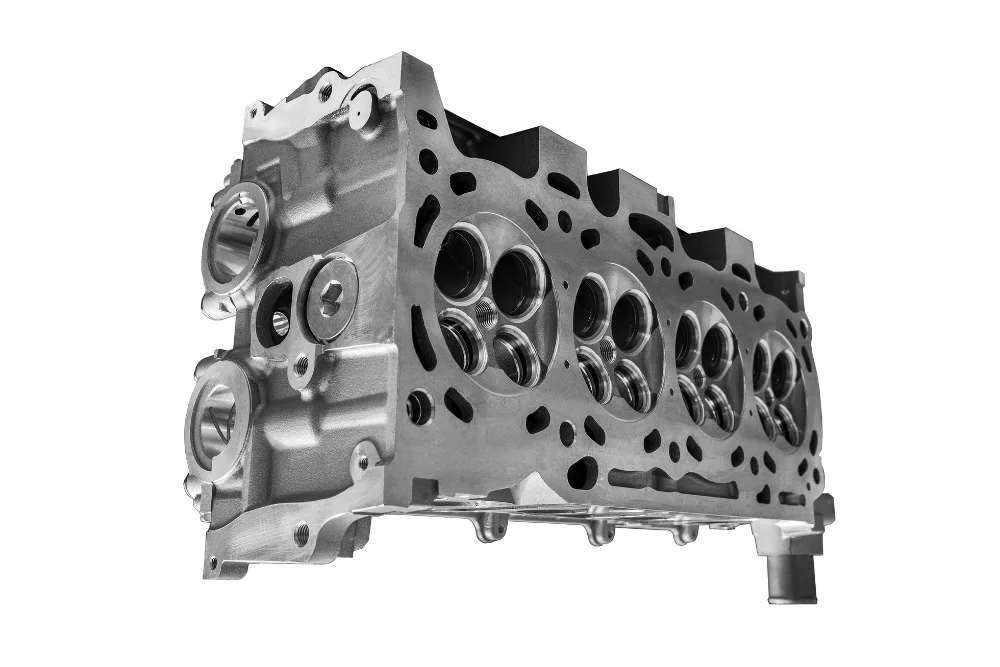 metal engine cylinder head with visible intake and exhaust ports isolated on white background